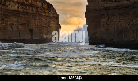 Alla Gola Loch Ard beach sulla Great Ocean Road all alba con forti onde la rottura tra scogliere calcaree a stretto ingresso alla baia. Foto Stock