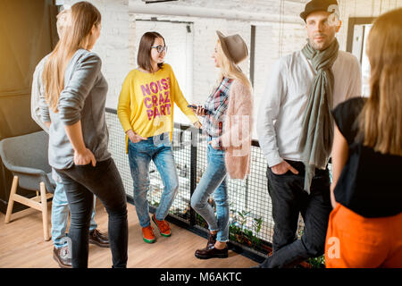 Gli amici di parlare durante la pausa nella sala conferenze Foto Stock