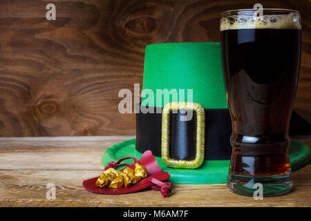 Saint Patrick day simboli leprechaun verde hat e grande bicchiere di birra scura Foto Stock