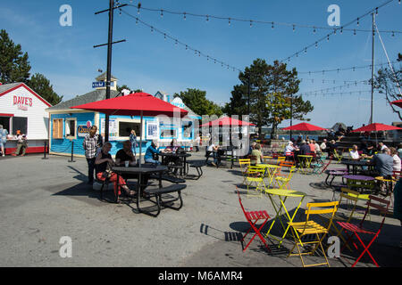 Mangiare fuori sul fronte mare Halifax Nova Scotia sedie gialle tavolo metallo caffè cabina cabine Harbour cafè filo luci cavo sedersi a parlare Foto Stock