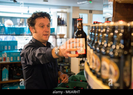 Il manager dell'Harvey's Brewery real ale shop di Lewes, East Sussex. Foto Stock