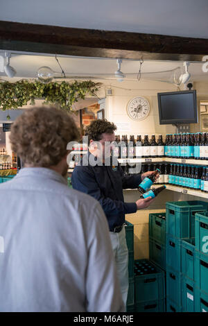 Il manager dell'Harvey's Brewery real ale shop di Lewes, East Sussex. Foto Stock