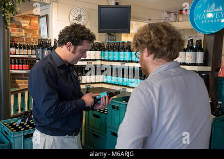 Il manager dell'Harvey's Brewery real ale shop di Lewes, East Sussex. Foto Stock