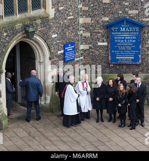 Arsenal Manager Arsene Wenger passa da come il Reverendo John Samways (un amico di famiglia e di Watford sostenitore di 64 anni) parla con Rita Taylor & fami Foto Stock