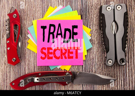 La scrittura di un testo che mostra il segreto commerciale. Il concetto di business per la protezione dei dati scritti su sfondo di legno con coltellino tascabile con uno spazio Foto Stock
