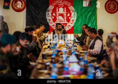 Il sig. Hayatullah Hayat, governatore della provincia di Helmand, condivide un pasto con i principali leader dalla Task Force Southwest (TFSW), la nazionale afghano di difesa e di sicurezza vigenti (ANDSF), e gli anziani del villaggio dal Nahr-e- Saraj quartiere al Camp Jadeed, Afghanistan, Feb 15, 2018. I capi di Stato e di governo di TFSW e il ANDSF condotto una shura con anziani locali dal Nahr-e- Saraj distretto per acquisire una maggiore conoscenza della zona di sicurezza della situazione. Il ANDSF sono continuamente al lavoro per aumentare la stabilità per il popolino locale mentre persistentemente combattendo contro il nemico con il supporto di TFSW. (U.S. Marine Foto Stock