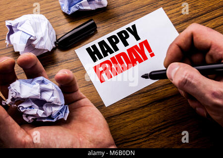 Testo della scrittura Venerdì felice . Concetto per il week-end accogliente scritto su notebook nota carta su sfondo di legno con carta ripiegata senso pensare f Foto Stock