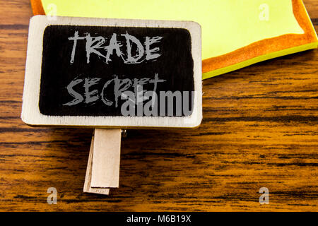 Il testo scritto a mano che mostra il segreto commerciale. Il concetto di business per la protezione dei dati scritti sulla scheda annunci su legno di legno dello sfondo. Foto Stock