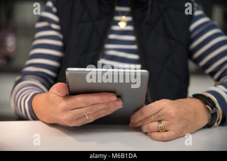 Close up della donna la lettura di una compressa. Messa a fuoco selettiva Foto Stock