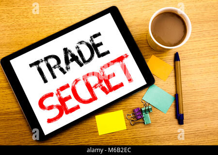 Il testo scritto a mano la didascalia che mostra il segreto commerciale. Il concetto di Business iscritto per la protezione dei dati scritti su tablet, sullo sfondo di legno con una nota adesiva e Foto Stock