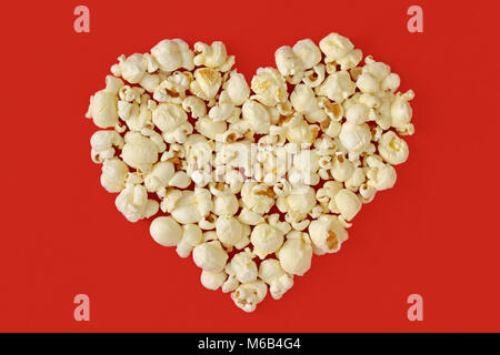 Pop corn cuore su sfondo rosso Foto Stock