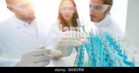 Immagine di sfondo è un gruppo di scienziati che studiano il liquido in Foto Stock