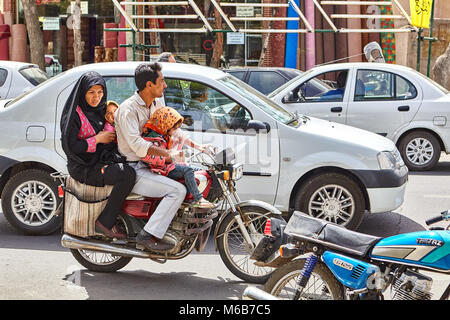 Kashan, Iran - 27 Aprile 2017: una famiglia di quattro persone, due bambine con i loro genitori, guidare una moto su una strada di città nel traffico. Foto Stock