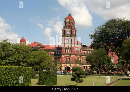 Ex coloniale di mattoni rossi la costruzione dell'Alta Corte con la sua torre dell'orologio, Yangon, Myanmar. Foto Stock