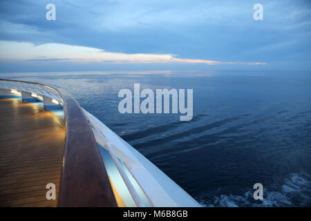 Twlight su una nave da crociera deck, a vela attraverso la calma oceano. Foto Stock