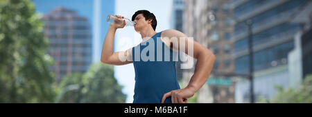 Immagine composita di basso angolo di visione del giovane di acqua potabile Foto Stock