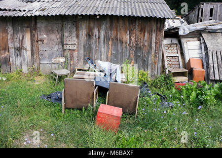 Un villaggio di discarica di rifiuti nei pressi di legno capannoni distrutti. Estate Agosto Giornata europea del paesaggio risol Foto Stock