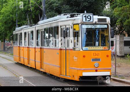 BUDAPEST, Ungheria - 20 giugno 2014: la gente ride orange Il tram a Budapest. Esso è parte di BKK sistema di trasporti pubblici che serve 1.4 miliardi di marcia annuale Foto Stock