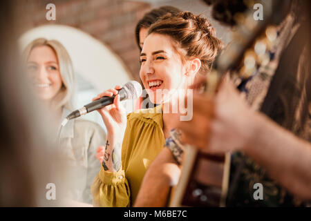 Entertianment a un matrimonio. Una cantante femminile è interagire con la folla mentre un uomo suona la chitarra acustica. Foto Stock