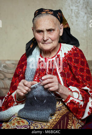 Vecchia donna rumena in costume tradizionale maglia Foto Stock