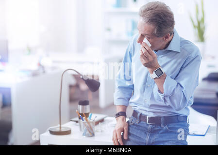 Piacevole piacevole uomo tenendo un fazzoletto di carta Foto Stock