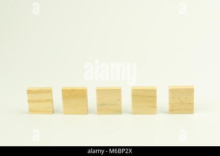 Fila di cinque sbozzato di blocchi di legno su sfondo bianco con copyspace per il testo Foto Stock
