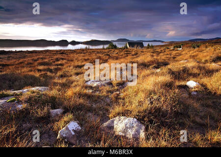 Un inverno vista attraverso la Wester Ross costa guardando verso l'estate isole come il sole tramonta. Foto Stock