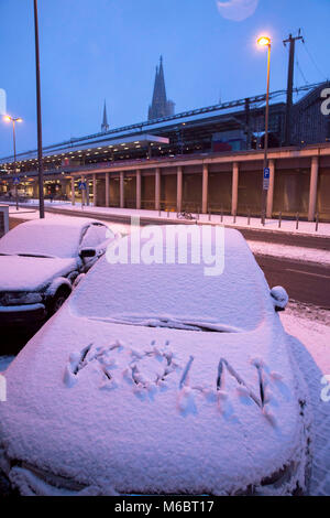 Germania, Colonia, snow-auto coperto con Koeln (Colonia) scrivendo sul cofano vicino alla stazione principale e sullo sfondo la cattedrale. Deutschland, koel Foto Stock