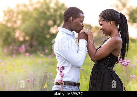 Coppia giovane in un romantico abbraccio in un campo. Foto Stock