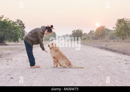 Amicizia tra uomo e cane - agitando la mano e paw Foto Stock