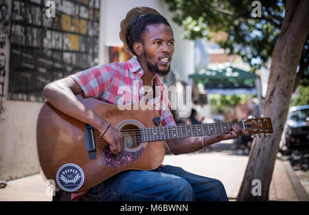 L'uomo africano a suonare la chitarra per le strade. Foto Stock