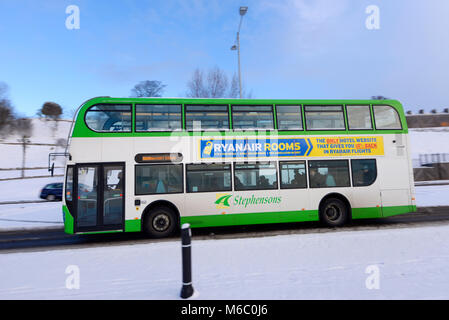 Stephensons scuola bus autobus che trasporta i bambini nelle scuole di Westcliff. Route 509 Westcliff scuole. Guida su strada innevata dalla Bestia da est Foto Stock