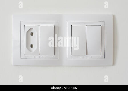 Interruttore luce di presa sul muro bianco vista ravvicinata Foto Stock