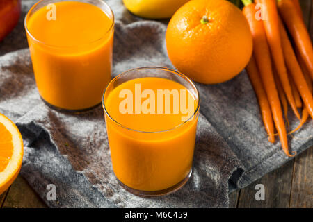 Sana arancione organico frullato di carote di bere succo di mango e banana Foto Stock
