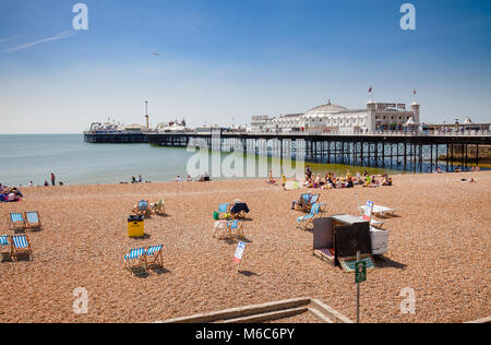 BRIGHTON, Regno Unito - 5 GIU 2013: Holidayers godendo di buona estate meteo a ciottoli vicino al palazzo di Brighton Pier Foto Stock