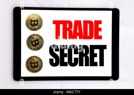 La scrittura di un testo che mostra il segreto commerciale. Il concetto di business per la protezione dei dati scritti su tablet schermo su sfondo bianco con cryptocurrency bitcoin accanto Foto Stock