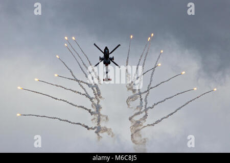 Elicottero in volo di sparare razzi di segnalazione Foto Stock