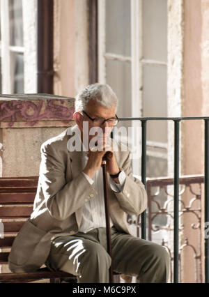 Senior uomo seduto su un banco di lavoro Foto Stock