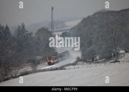Una Vergine Voyager in treno in una tempesta di neve a Thornhill a nord di Dumfries, il treno è stato deviato a causa di un danneggiamento del ponte sulla linea principale della costa occidentale Foto Stock