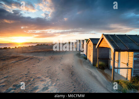 Tramonto mozzafiato sulla spiaggia di capanne a West Wittering sulla costa del Sussex Foto Stock