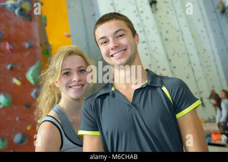 Coppia giovane dando alta cinque in una palestra di arrampicata Foto Stock