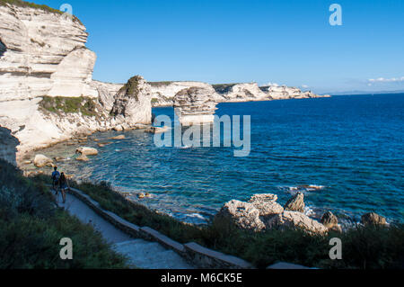 Corsica: la mozzafiato bianche scogliere calcaree nella International Bouches de Bonifacio parco marino con vista del capo Pertusato faro Foto Stock