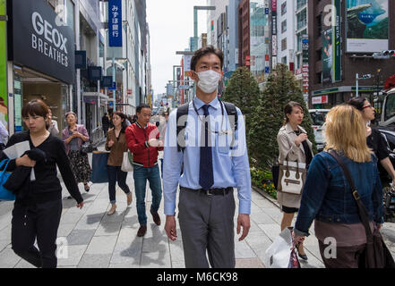 Uomo che indossa una maschera coronavrius per strada nel distretto di Ginza di Tokyo, Giappone Foto Stock