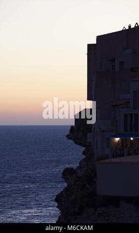 Corsica: tramonto sulla skyline del centro storico di Bonifacio, città sulla punta meridionale dell'isola, costruito sulla sommità di bianche scogliere calcaree Foto Stock