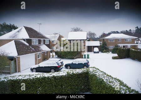 Moderno complesso residenziale nella neve con macchine parcheggiate Foto Stock