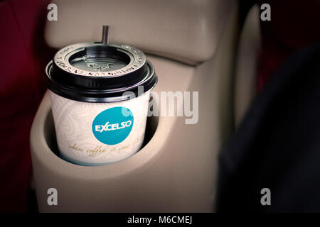 Una tazza di caffè excelso in auto, a bere la maniglia Foto Stock