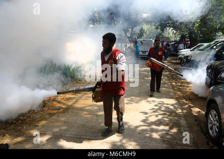 Un dipendente di Dhaka città del nord Corporation spray insetticida per uccidere le zanzare all università di Dhaka area. Dhaka 2018. Foto Stock