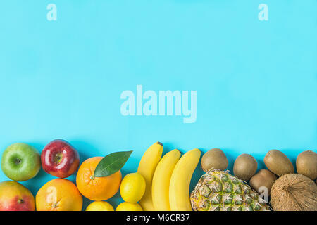 Varietà di differenti tropicale e stagionali estivi frutti. Ananas Manghi Agrumi Noce di Cocco Arance Limoni Mele Kiwi banane disposto nel bordo inferiore Foto Stock