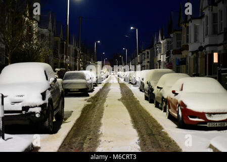 Auto coperto di neve a Westcliff on Sea, Essex, dalla bestia da est meteo fenomeno. Strato di neve sulla strada con segni di traffico precoce Foto Stock