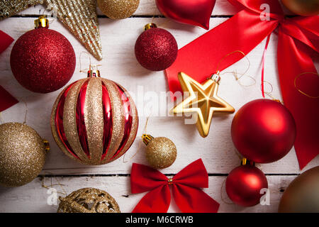 Buon Natale con telaio in vero legno verde di pini, colorato baubles confezione regalo e altra roba stagionale su un vecchio invecchiato in legno sfondo. Foto Stock